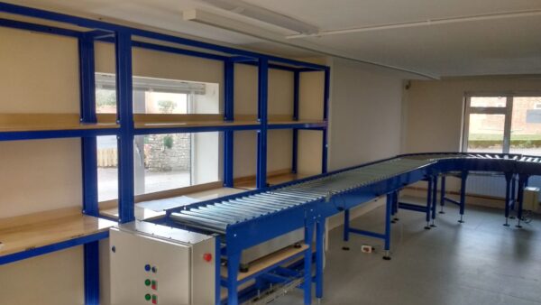 Driven roller conveyor with blue framed shelving workstations