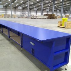Long blue workstation with cupboards installed in a warehouse